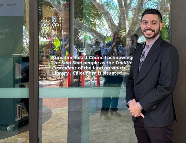 Bunin Director, Alec standing next to acknowledgement of Traditional Owners signage outside Caloundra Library
