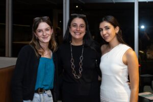 Three attendees standing together smiling at camera at Design for a Difference Event 2025