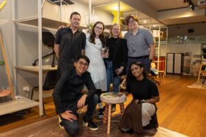 Six attendees standing together smiling at camera at Design for a Difference Event 2025