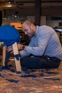 Male participant covering table top at Design for a Difference Event 2025