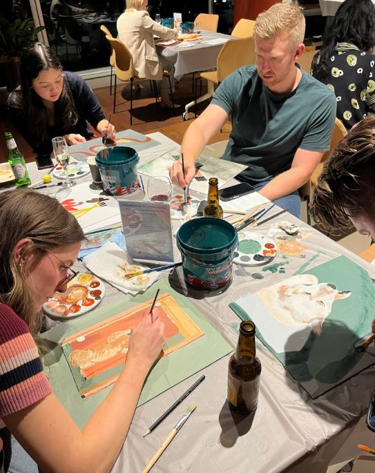 Three participants painting at Design for a Difference event 2026