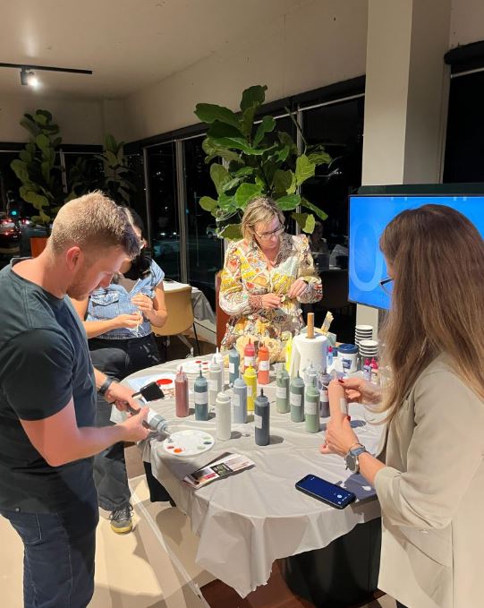 Three participants preparing to paint at Design for a Difference event 2026