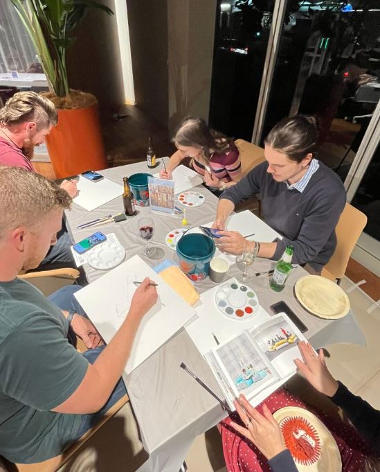 Four participants starting to paint at Design for a Difference event 2026